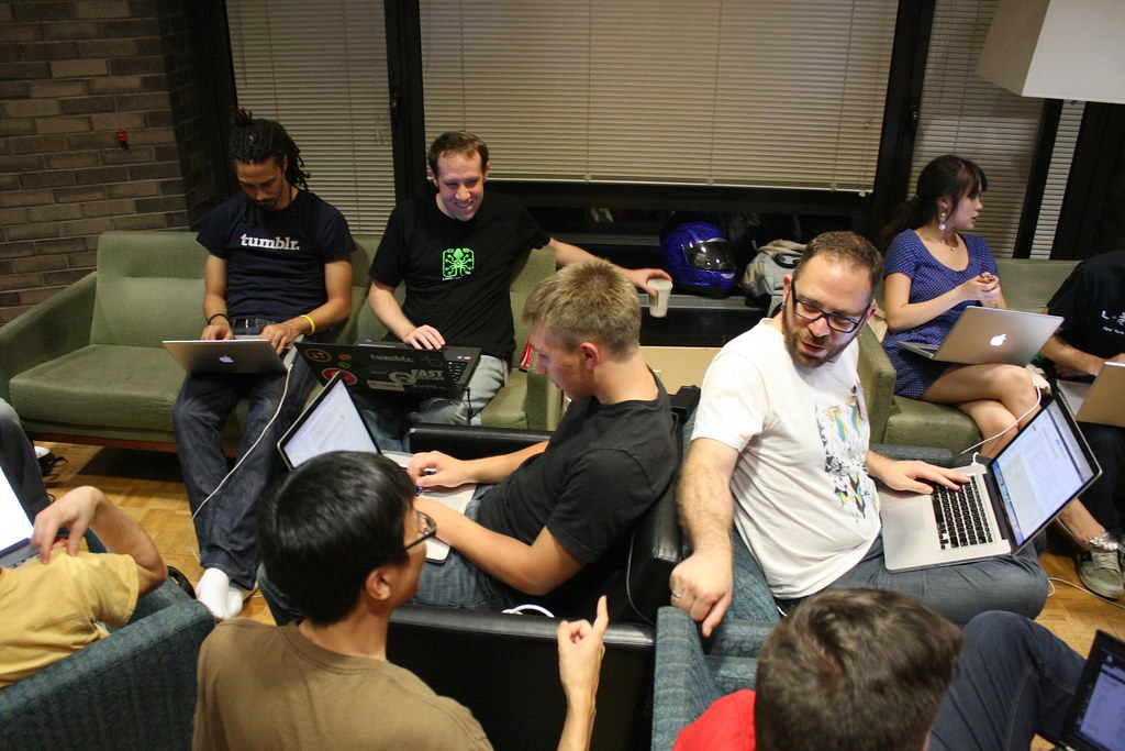 A group of people coding using their computers